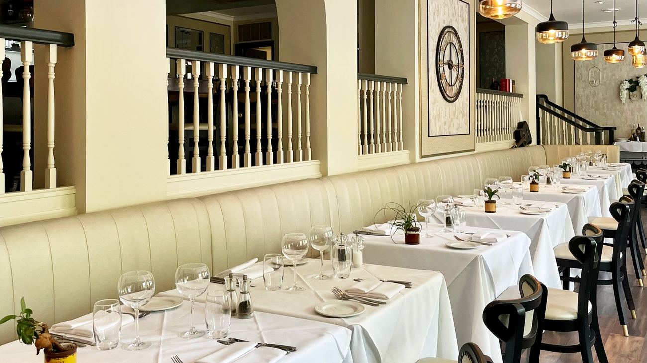A private dining room at La Meridiana, tables laid with white linen